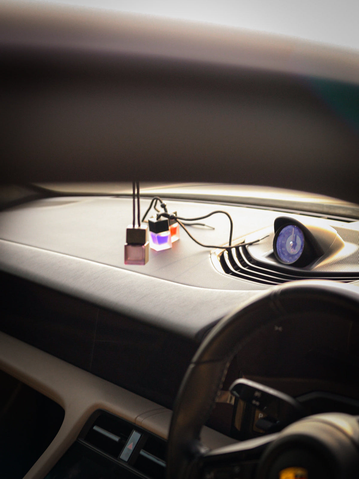 SCNTD Signature frosted blue car diffuser inspired by Azzaro Most Wanted, hanging from rearview mirror inside a car
