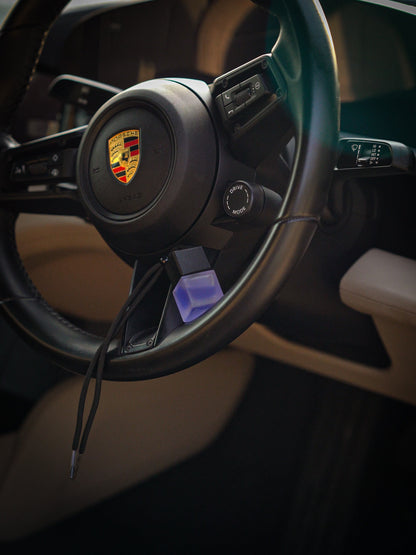 SCNTD Signature blue and purple car diffuser bottles resting on car dashboard with colorful fragrance lineup